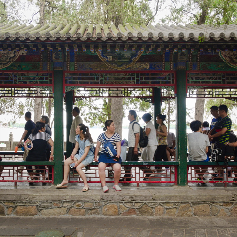Tourists walking through the open-air Long 
				Corridor at the Summer Palace in Beijing, China